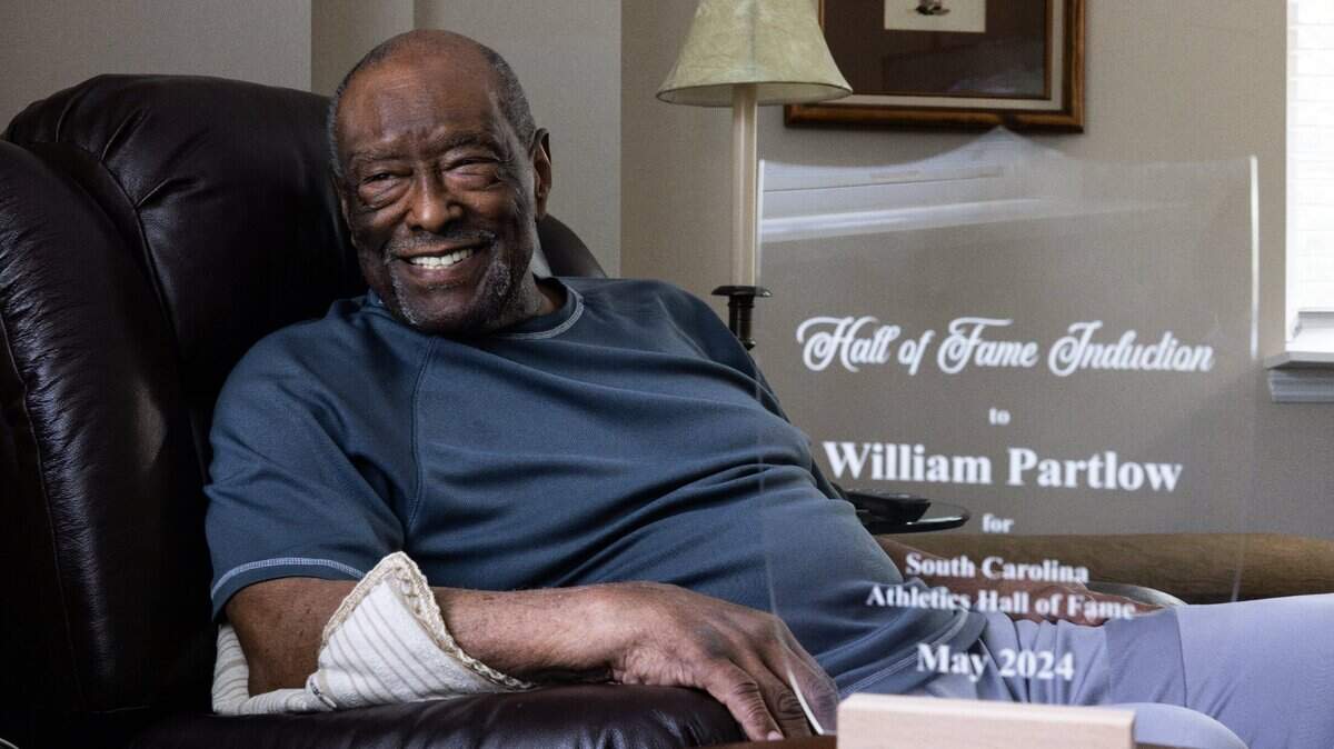 William Partlow poses for a portrait with a plaque that a family member made for him in Charlotte, N.C., on Thursday, May 16, 2024.